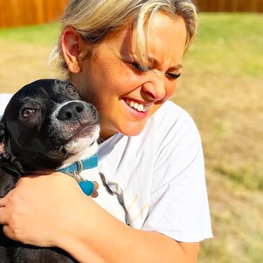 Sitter hugging a black dog
